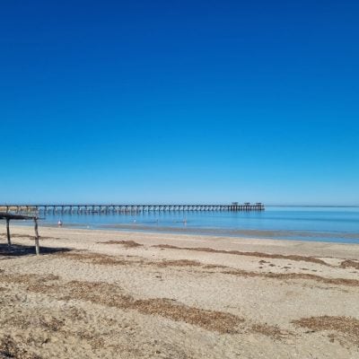Calm beach with a long wooden pier