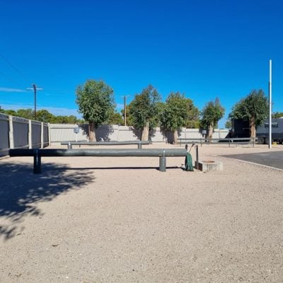 Wide view of a gravel area with trees.