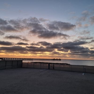 Sunset over a calm sea and pier at Smoky Bay Caravan Park