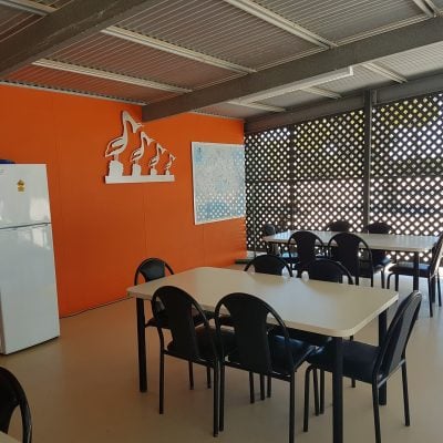 Indoor camp kitchen at Smoky Bay Caravan Park with two dining tables, fridge, microwave